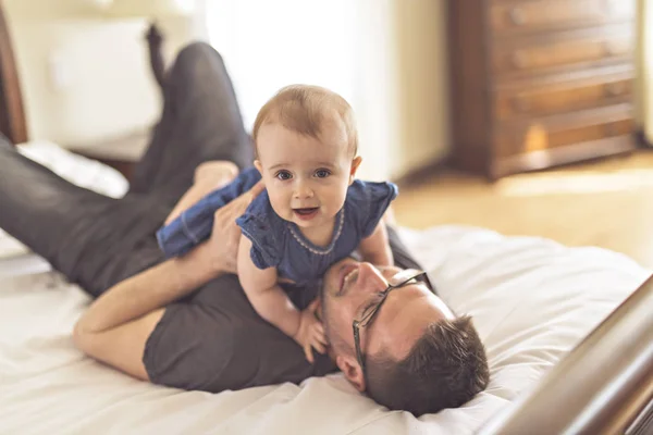 Padre jugando con su bebé en el dormitorio — Foto de Stock