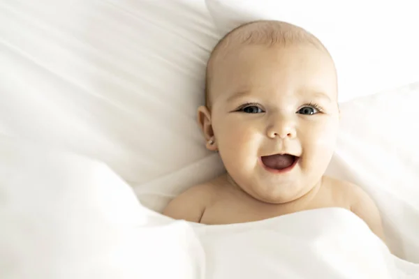 Evde beyaz bir yatakta bir kız şirin bebek — Stok fotoğraf