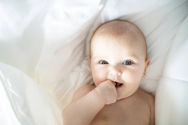一个可爱的女婴在白色的床在家里 — 图库照片