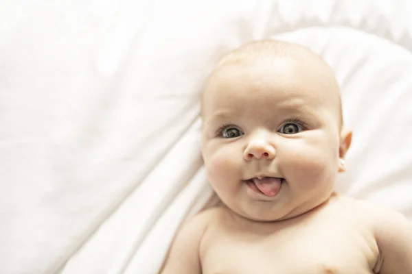 A Cute baby girl on a white bed at home — Stock Photo, Image