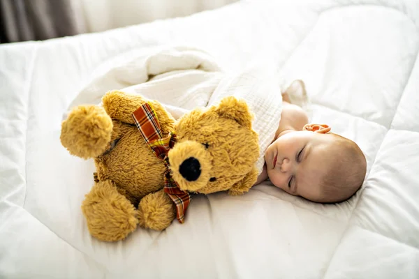 4 miesiąca dziecko śpiące na białym łóżku w domu z misia — Zdjęcie stockowe