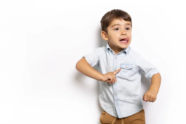 Menino se divertindo no estúdio cinza fundo — Fotografia de Stock