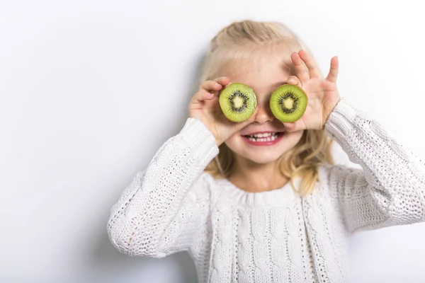 Aranyos lány 4-5 éves pózol a fruit kiwi stúdió — Stock Fotó