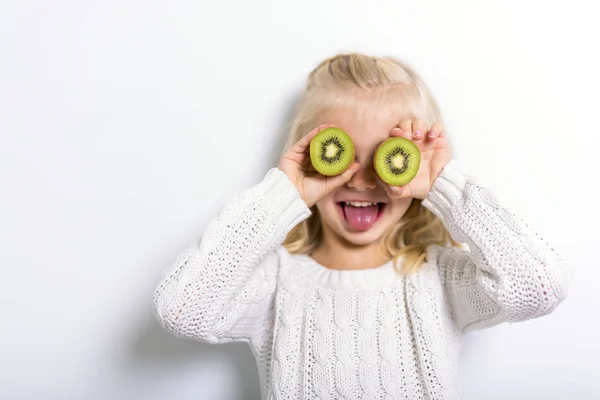 Aranyos lány 4-5 éves pózol a fruit kiwi stúdió — Stock Fotó