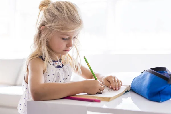 Маленька дівчинка малює на кухонному столі — стокове фото