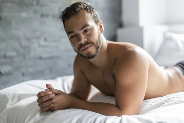 Mladý Mexický muž bez košile v bílé posteli — Stock fotografie