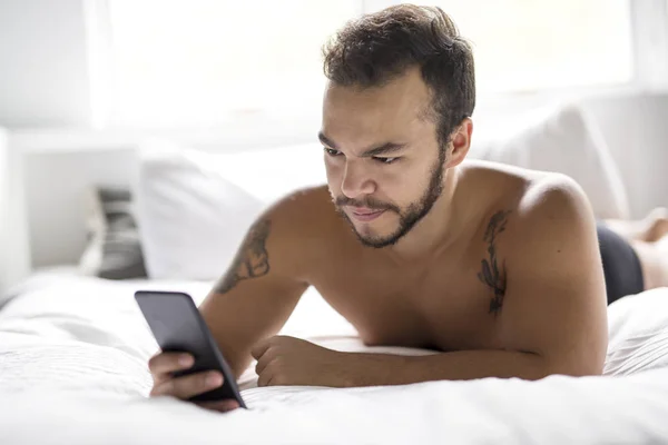 Mladý Mexický muž bez košile v bílé posteli — Stock fotografie