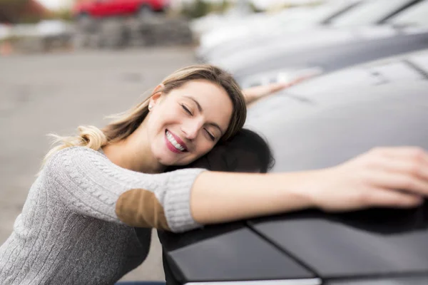 Jolly joven conductora abrazando su nuevo coche — Foto de Stock