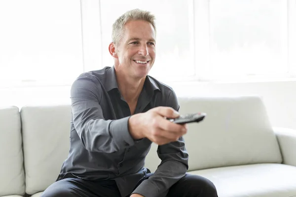 Portrait of single 40s man sitting in sofa tv remote — Stock Photo, Image