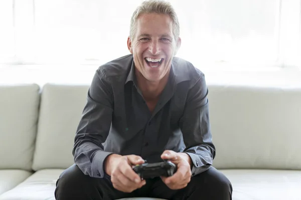 Portrait of single 40s man sitting in sofa play video game — Stock Photo, Image