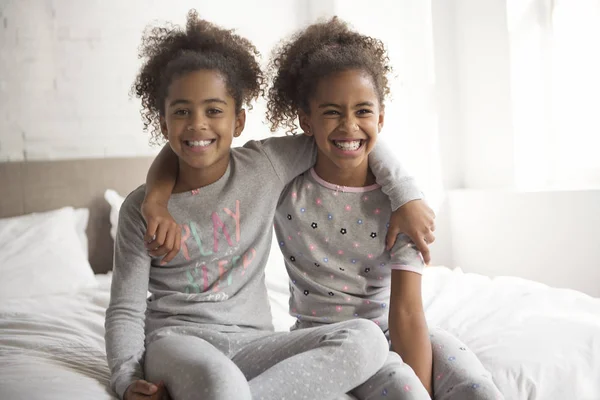 Dos niñas afroamericanas en la cama en casa —  Fotos de Stock