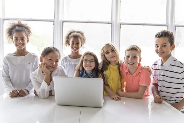 Группа любопытных детей, смотрящих на экране ноутбука — стоковое фото