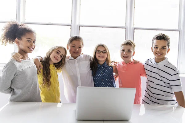 Группа любопытных детей, смотрящих на экране ноутбука — стоковое фото