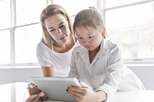 Skolflicka forska på nätet med vägledning av sin lärare — Stockfoto