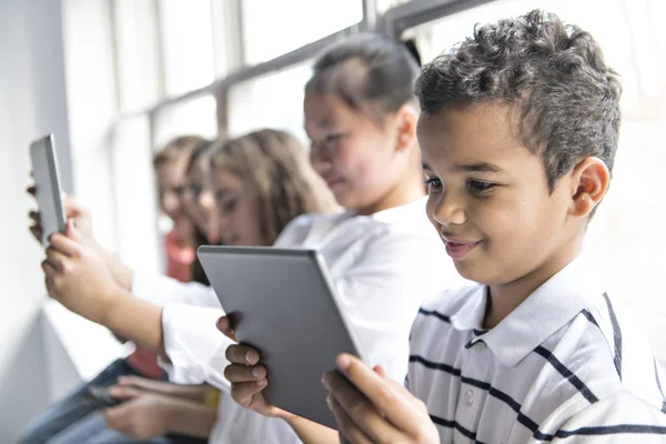 Grupa ciekawskich dzieci oglądających rzeczy na ekranie tabletu — Zdjęcie stockowe