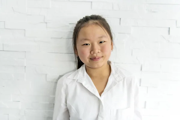 Cute pretty asian child girl near light brick wall — Stock Photo, Image
