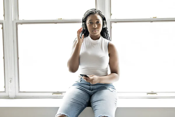 Genç teen güzel Afrikalı-Amerikalı kadın kulaklık ile müzik dinlemek sahiptir — Stok fotoğraf
