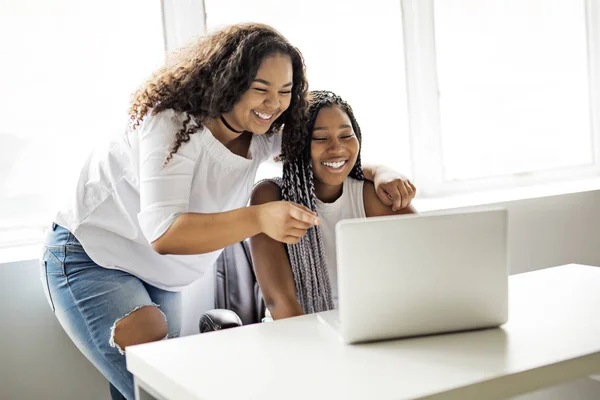 Deux adolescents au bureau dans son bureau avec ordinateur portable pointant — Photo