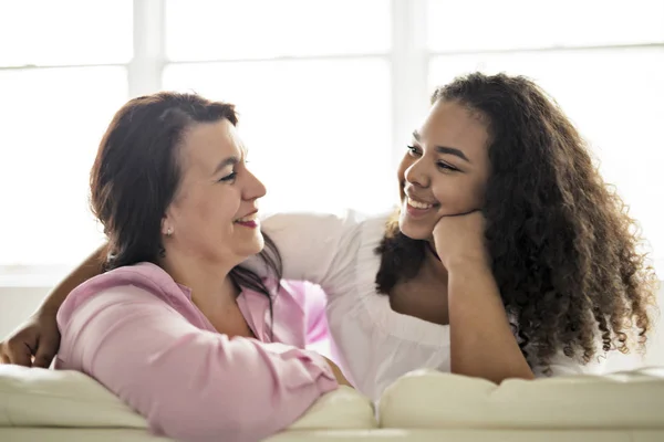 Liebevolle Mutter und Tochter auf Sofa sitzend — Stockfoto