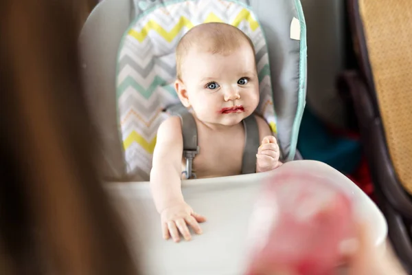 Madre alimentación bebé niña en silla alta — Foto de Stock