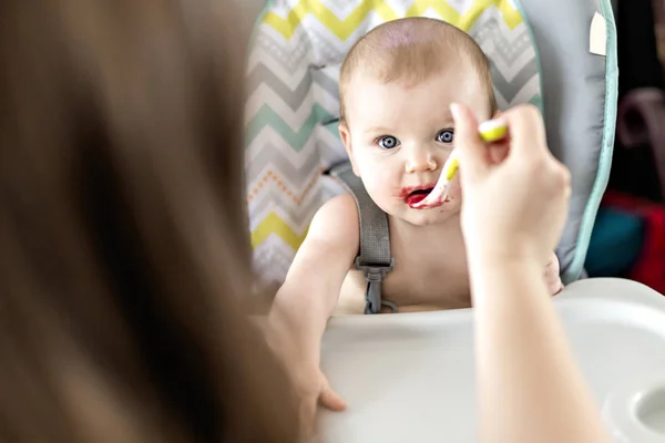 Mère nourrissant bébé fille en chaise haute — Photo