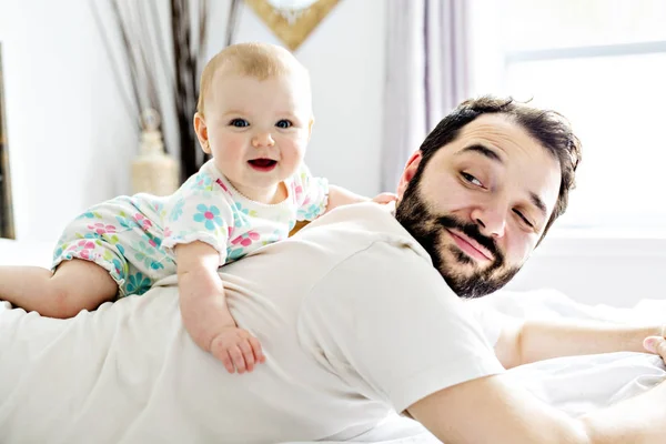 Jovem pai feliz brincando com cama de babyon — Fotografia de Stock