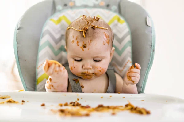 Kleine baby eet haar eten en maakt er een puinhoop van — Stockfoto
