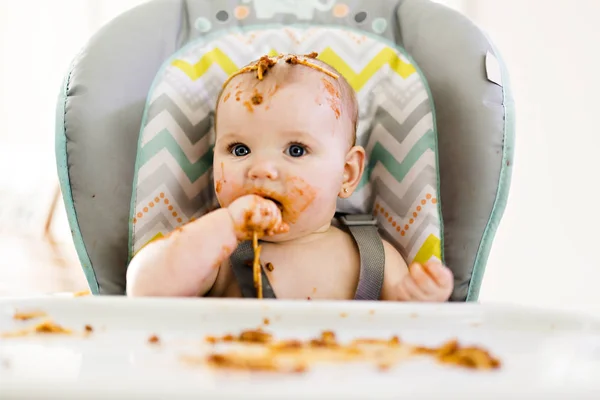 Piccolo bambino mangiare la sua cena e fare un pasticcio — Foto Stock