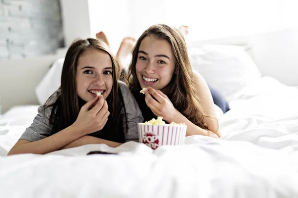 Amistad, gente, fiesta de pijama, entretenimiento y comida chatarra concepto — Foto de Stock