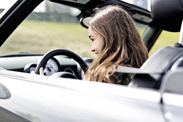新しい車で若いブルネットの女性 — ストック写真