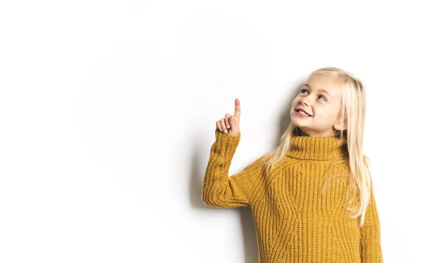 Una linda chica de 5 años posando en el estudio señalando — Foto de Stock