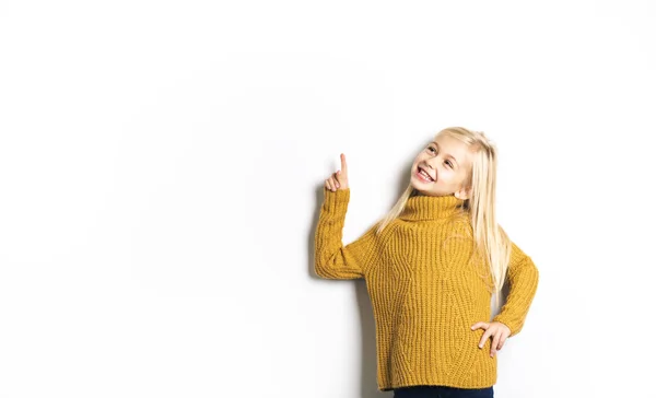 Uma menina bonito 5 anos posando em estúdio apontando — Fotografia de Stock