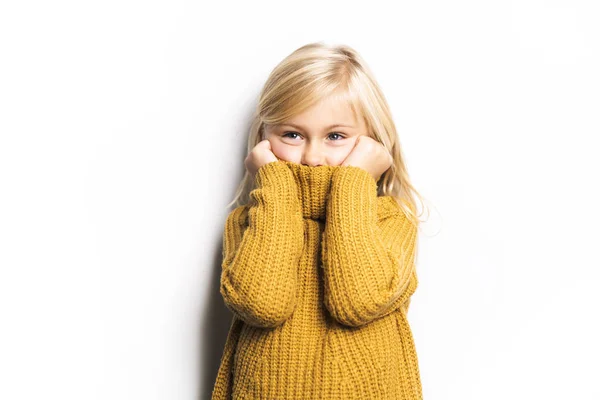 Una linda chica de 5 años posando en un estudio con aspecto congelado , — Foto de Stock