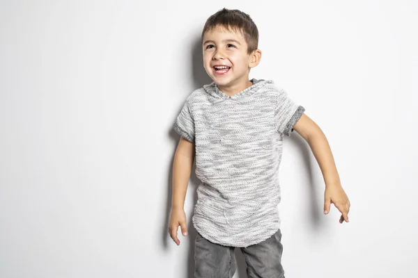 Menino se divertindo no estúdio fundo branco — Fotografia de Stock