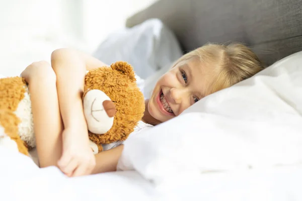 Ένα μικρό κορίτσι στο κρεβάτι στον ύπνο και όνειρα με αρκουδάκι, — Φωτογραφία Αρχείου