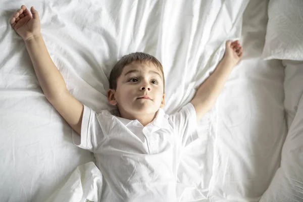 A Little boy lay on the bed with white blanket — Stock Photo, Image