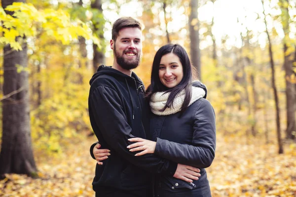 Una giovane coppia si diverte nel parco autunnale — Foto Stock