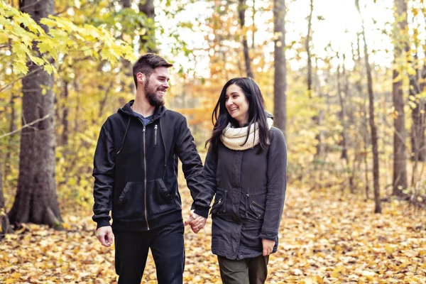 Egy fiatal pár szórakozik az őszi parkban — Stock Fotó