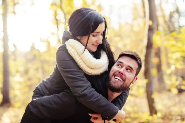 Una pareja joven divirtiéndose en el parque de otoño —  Fotos de Stock