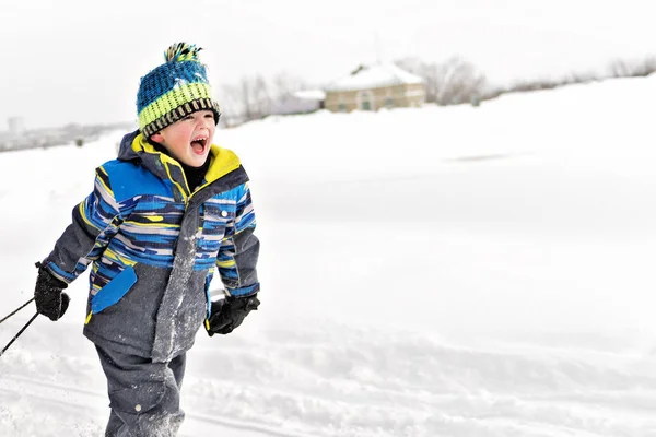 Un chico lindo en temporada de invierno afuera en la nieve — Foto de Stock