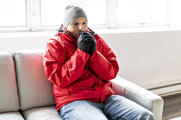A Man With Warm Clothing Feeling The Cold Inside House on the sofa — Stok Foto