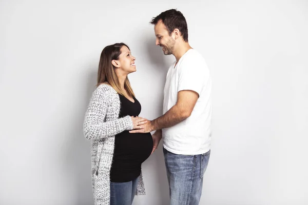 Una donna incinta con uomo in studio isolato su bianco — Foto Stock