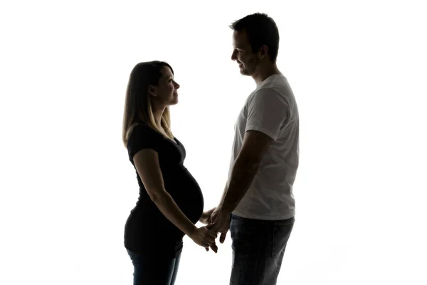 Eine schwangere Frau mit Mann im Studio isoliert auf weiß — Stockfoto