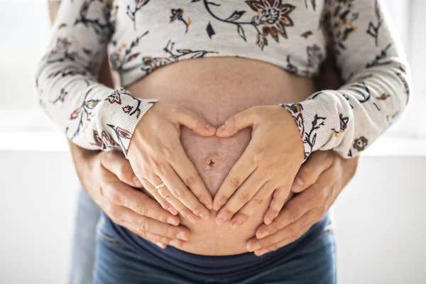 Imagen de la hermosa mujer embarazada y su apuesto marido abrazando la barriga —  Fotos de Stock