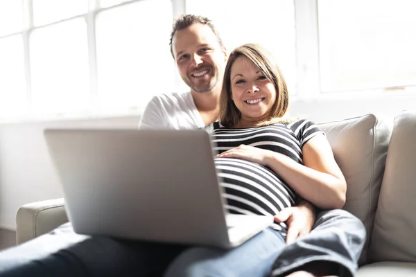 Ένα ζευγάρι με έγκυο γυναίκα χρησιμοποιεί το φορητό υπολογιστή μαζί — Φωτογραφία Αρχείου