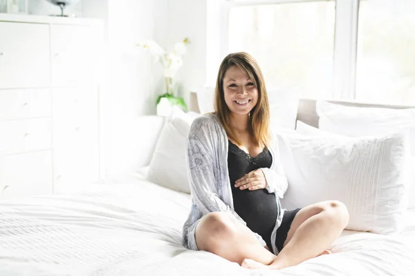 かなり若い妊婦はベッドに敷設 — ストック写真