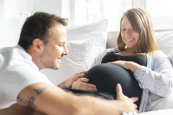 Un genitore a letto in attesa di un bambino piccolo, Momenti romantici per una coppia incinta — Foto Stock