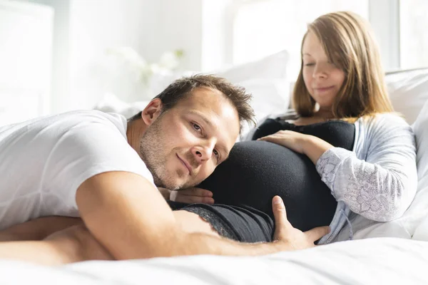 Een ouders in bed verwacht een beetje baby, romantische momenten voor zwangere paar — Stockfoto