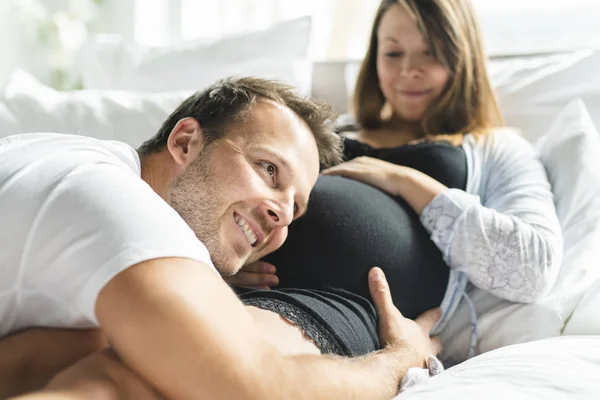 Eltern im Bett erwarten ein kleines Baby, romantische Momente für Schwangere — Stockfoto