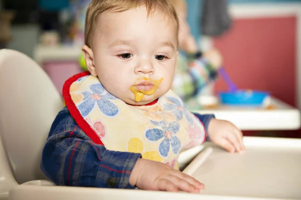 Een baby-kind eet voedsel op de kwekerij — Stockfoto